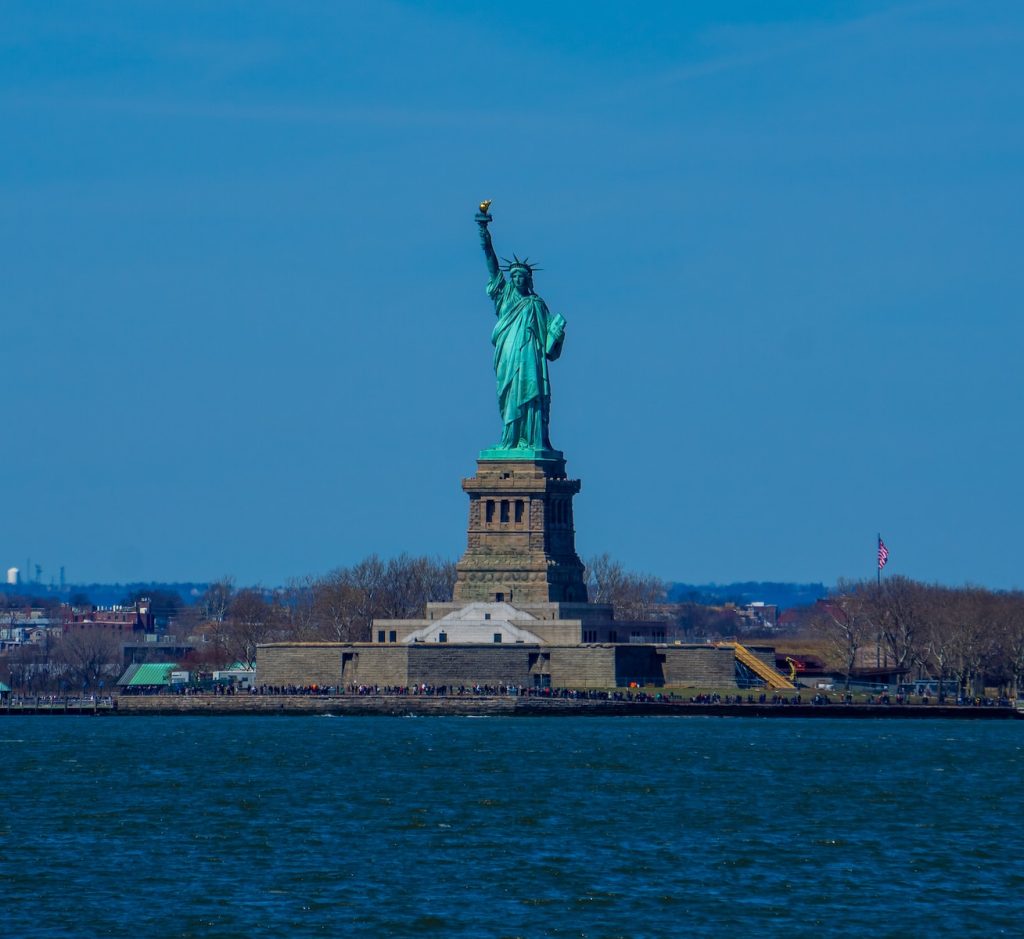 the statue of liberty stands in the middle of the water